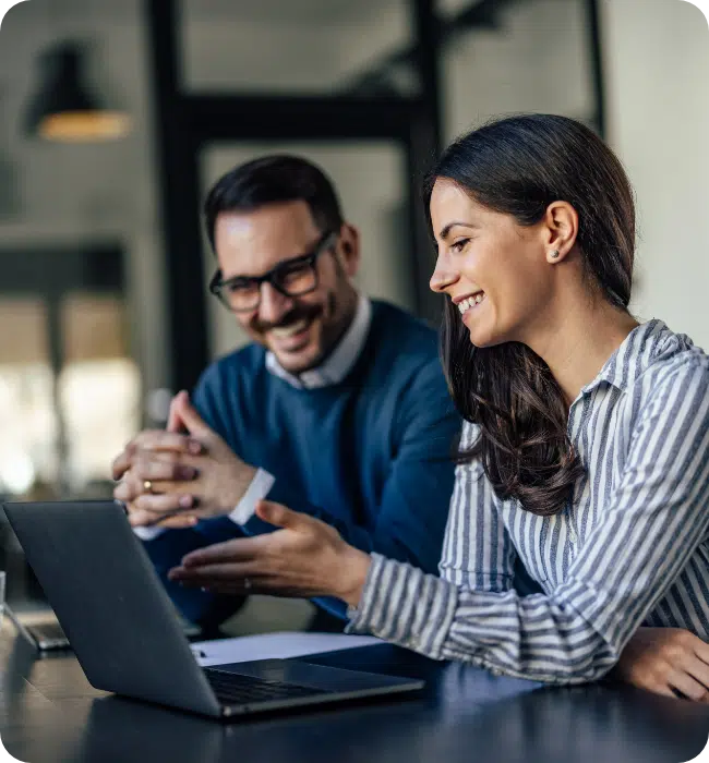 Happy business meeting between a man and woman looking at laptop